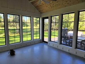 Vinyl 3-season sunroom with black frames offering unobstructed garden views
