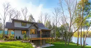 Lakeside cabin with dark aluminum picket railings around an elevated deck