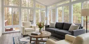 A comfortable seating layout turns a glass sunroom into an inviting place for fall gatherings.