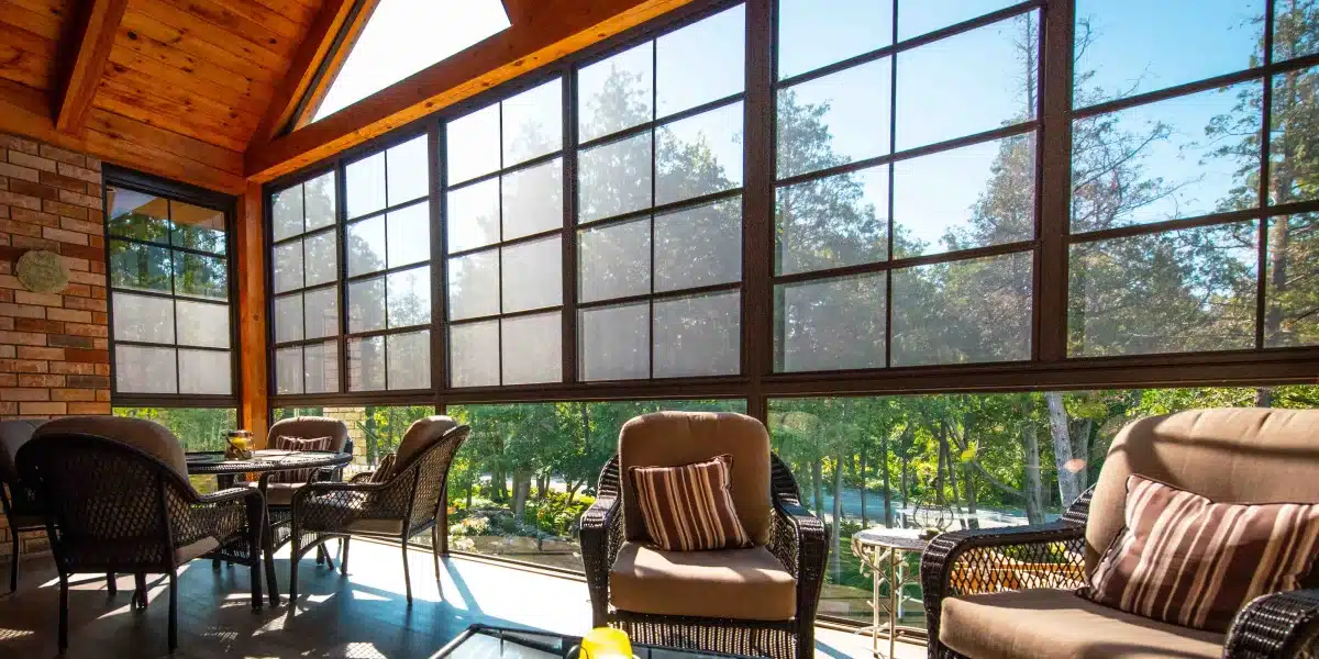 Enclosed porch with black-framed ViewFlex vinyl windows and wicker seating