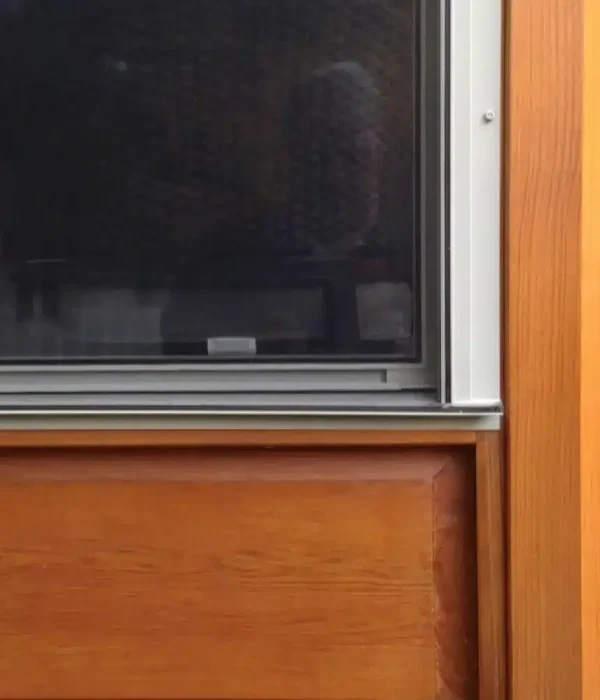 Close-up of integrated mesh screens and aluminum frames mounted on a wood porch