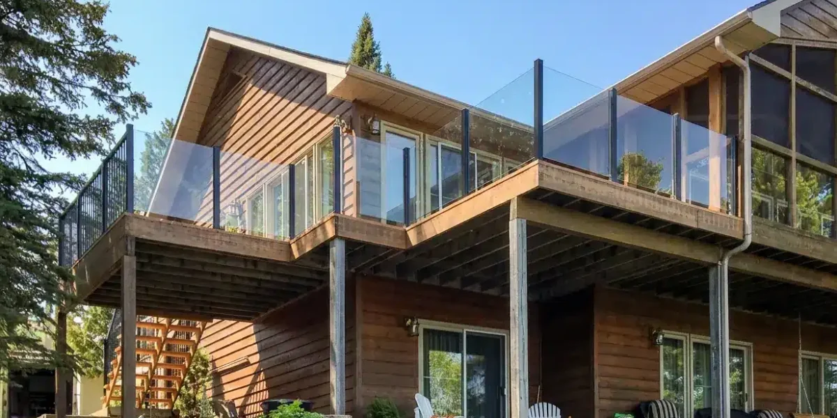 Topless glass railing installed around an elevated wood cabin deck